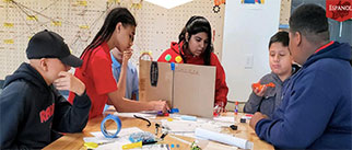 A group of kids working at a table on a project