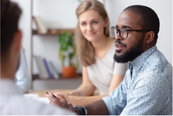Three professionals sitting at a table talking