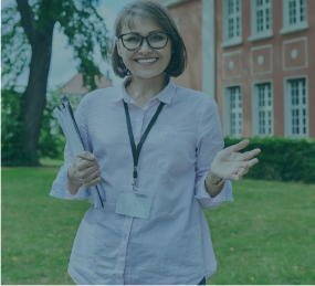 Woman with lanyard in front of school building